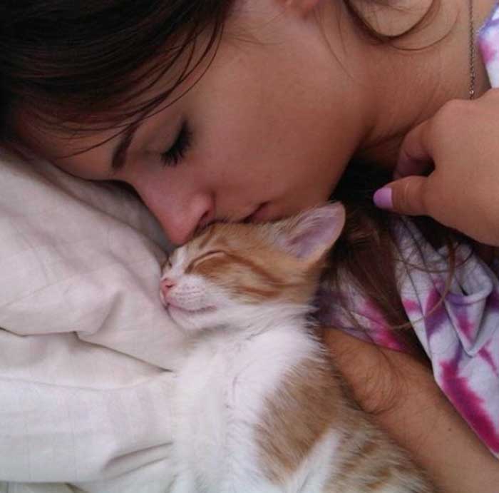 A picture of Lis Giolito sleeping with her cat.